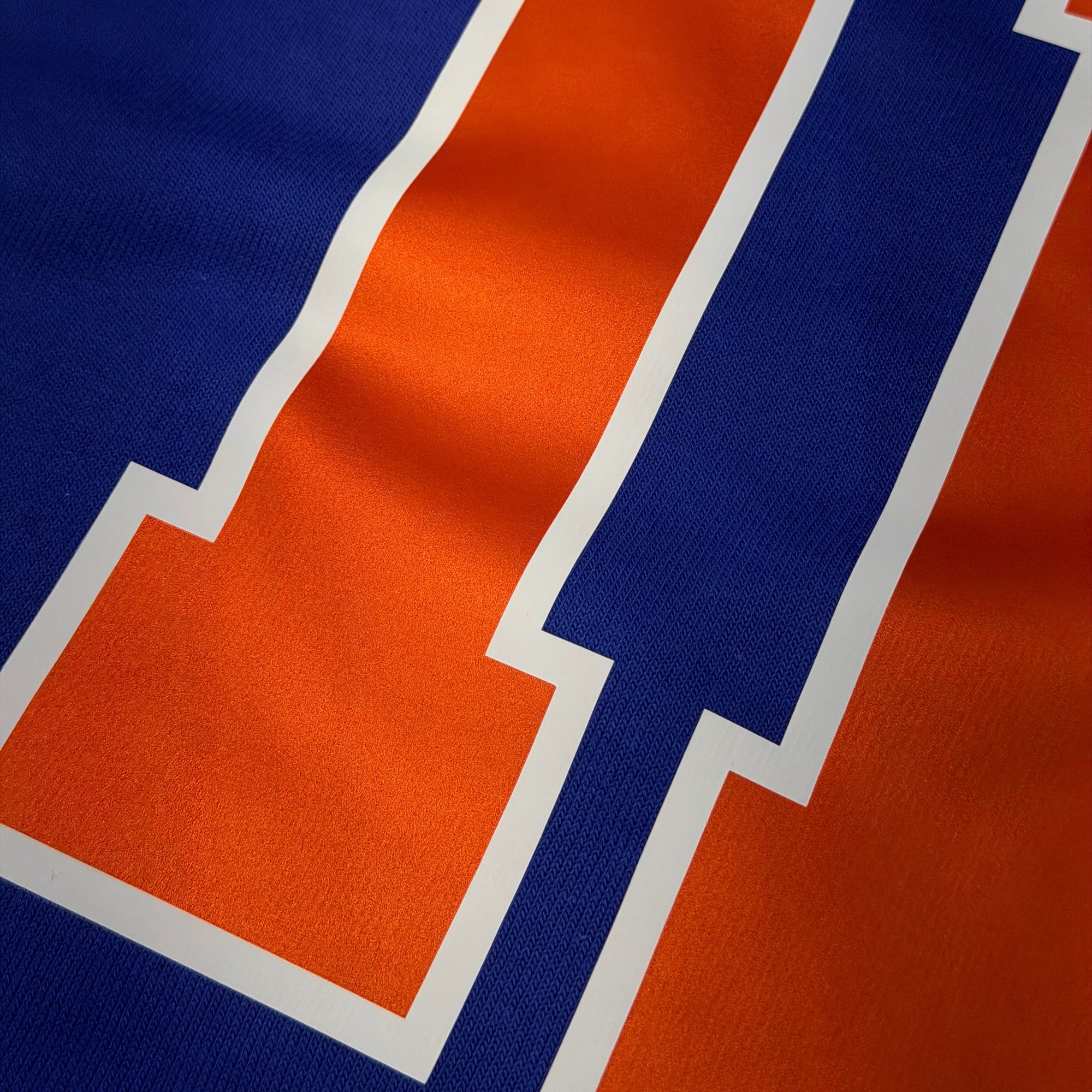 Close-up of a blue and orange logo on a fabric background